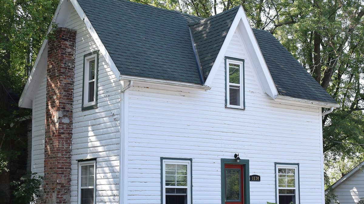 A white clapboard village house with a red door on O'Grady Street, Manotick